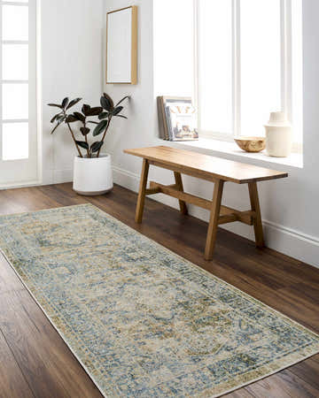 Hallway scene with Ember Washable Area Rug in blue, green, and sage. Wooden bench, plant, and art create a farmhouse style. Roomscene-Runner