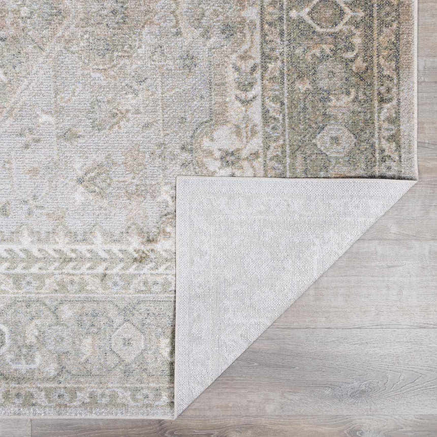 Close-up of Gael Boutique Washable Rug showing light blue, olive, and tan vintage pattern and machine woven construction. Fold