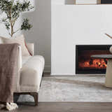 Living room scene with a light gray Gael Boutique Washable Rug, sofa, fireplace, and wood floors. Roomscene-Rectangle