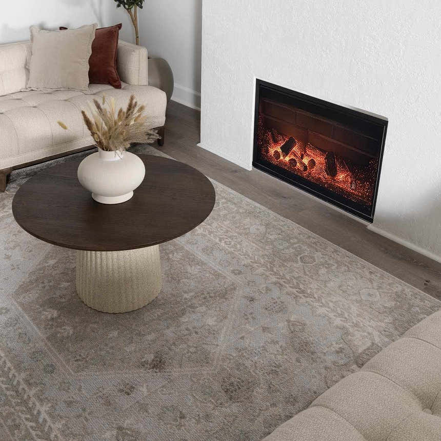 Living room scene with a light blue Gael Boutique Washable Rug, beige sofa, dark wood coffee table, and fireplace. Roomscene-Rectangle
