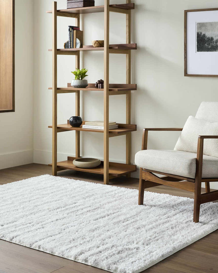 Living room scene with light wood shelving, chair, and Anevay Light Gray Area Rug. Roomscene-Rectangle