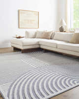 Living room with a gray and white geometric Deron Gray Rainbow Washable Rug under a modern sectional sofa. Roomscene-Rectangle