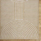 Close-up of the Deron Beige Washable Area Rug featuring a contemporary geometric pattern in beige and light brown. Corner