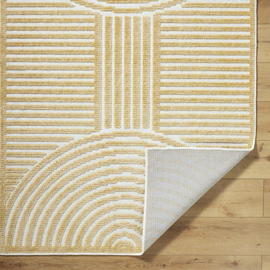 Close up of the Deron Mustard Washable Area Rug. Beige geometric pattern on off-white background. Shows rug backing. Fold