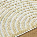 Close-up of Deron Mustard Washable Area Rug. Beige textured arches on an off-white background. Contemporary style. Texture