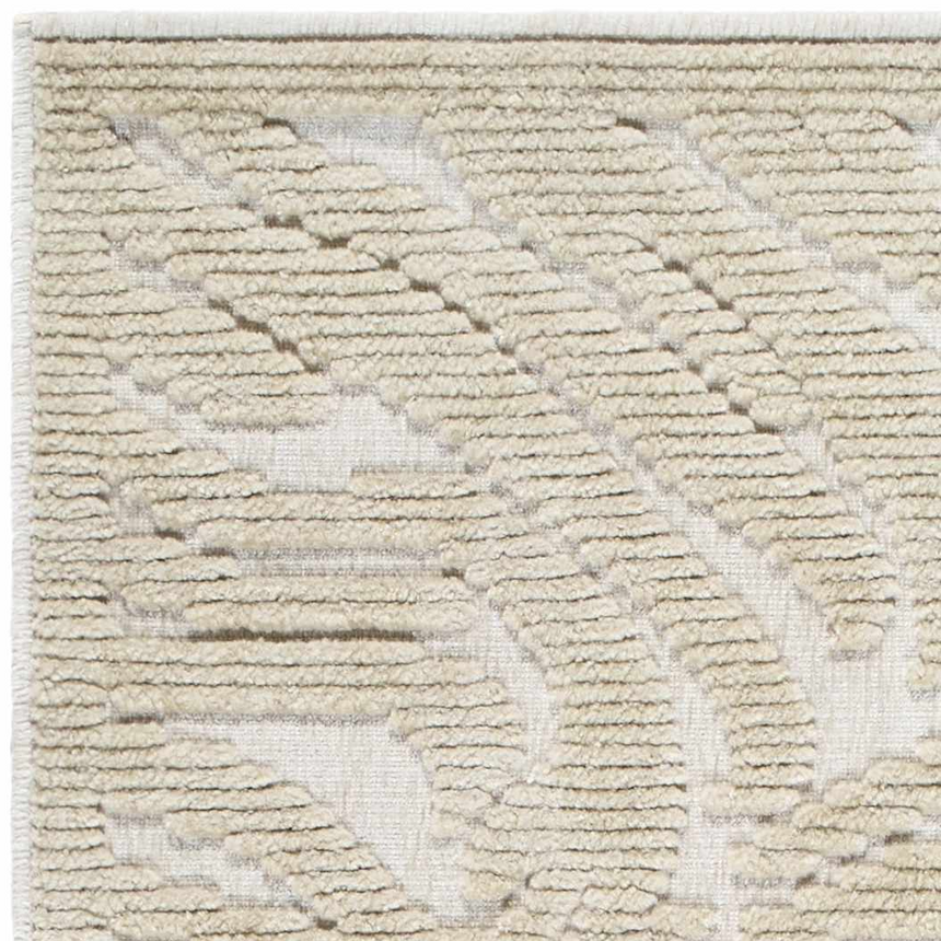 Close-up of the Keto Beige Washable Area Rug. Features a textured, geometric pattern in beige and light brown hues. Texture