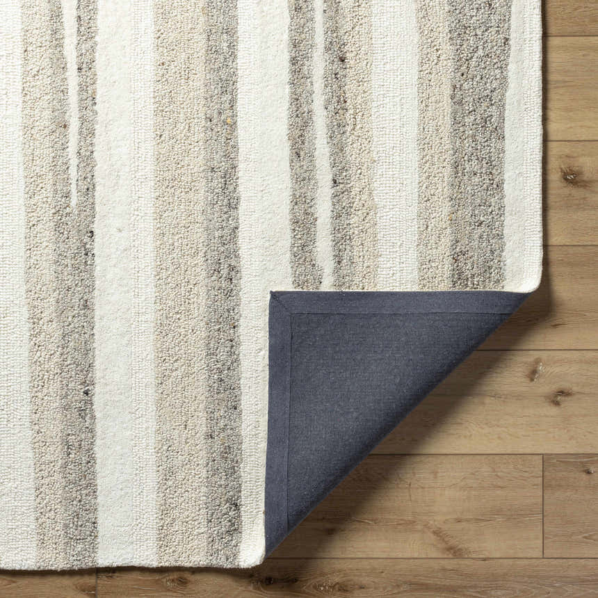 Close-up of the hand-tufted Siaju Taupe Area Rug. Features a striped pattern in neutral taupe and cream tones on a wood floor. Fold