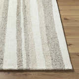 Close-up of the hand-tufted Siaju Taupe Area Rug. Features a striped pattern in taupe and white, with a textured wool pile. Front