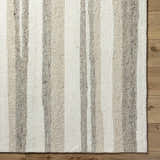 Close-up of the Siaju Taupe Area Rug. Hand-tufted wool rug with a striped pattern in neutral taupe and cream tones. Corner