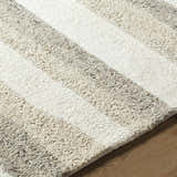 Close-up of the hand-tufted Siaju Taupe Area Rug. Features a textured, striped pattern in neutral taupe and white wool. Texture