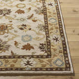 Close up of the hand-tufted Smoot Area Rug. Beige wool rug with brown, olive, and slate floral and geometric pattern. Front