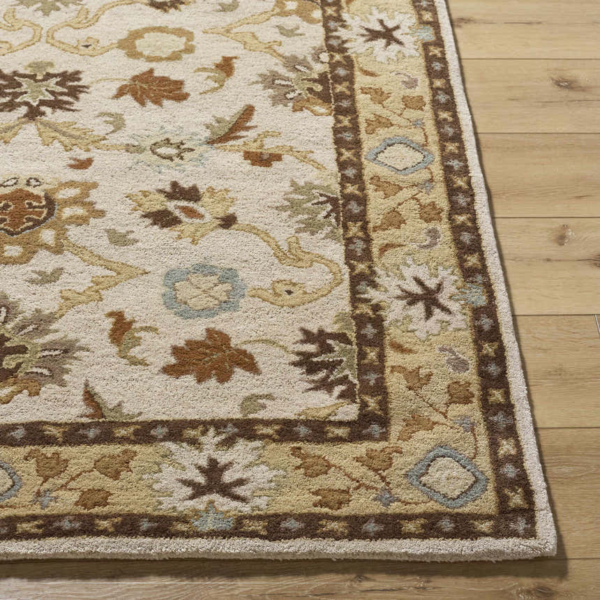 Close up of the hand-tufted Smoot Area Rug. Beige wool rug with brown, olive, and slate floral and geometric pattern. Front