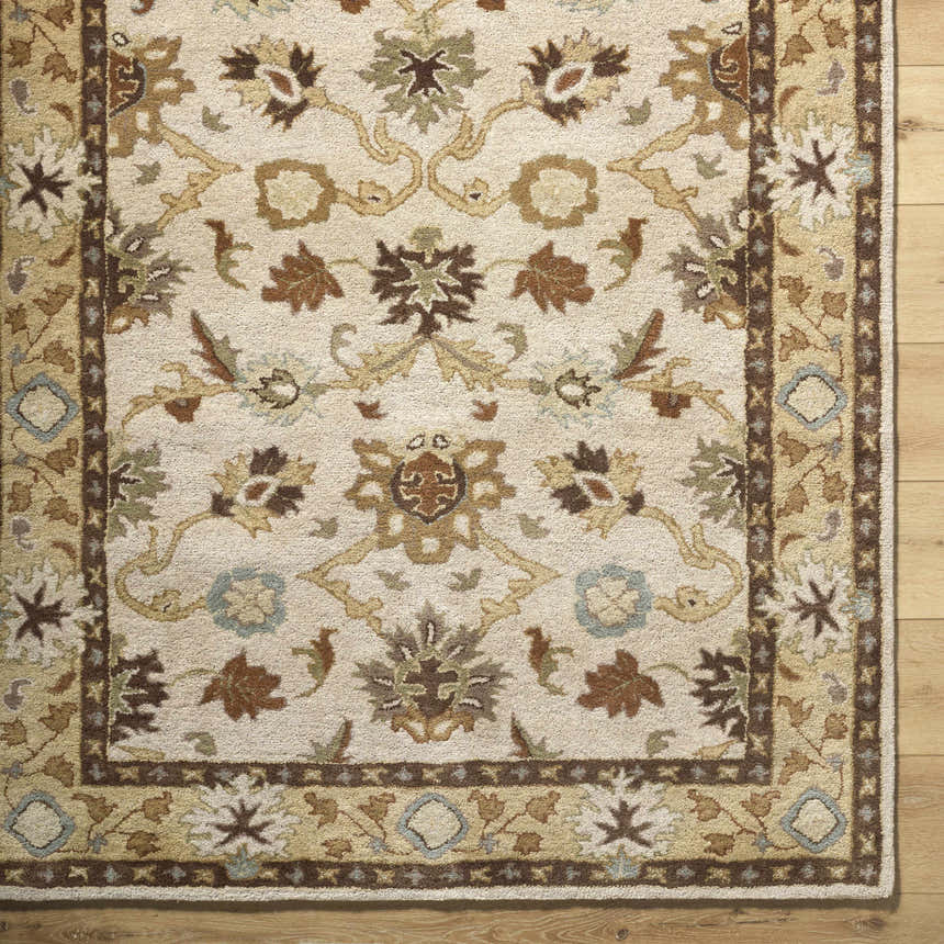 Close-up of the hand-tufted Smoot Area Rug. Beige wool rug with traditional brown, olive, and slate floral pattern. Corner