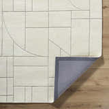 Close up of the Fusao Off White Area Rug showing the geometric pattern and wool texture. Fold