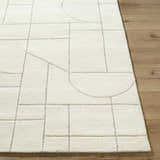 Close up of the Fusao Off White Area Rug showing its geometric pattern and wool texture. Front