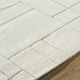 Close-up of the Fusao Off White Area Rug showing its textured wool and geometric, light silver pattern. Texture