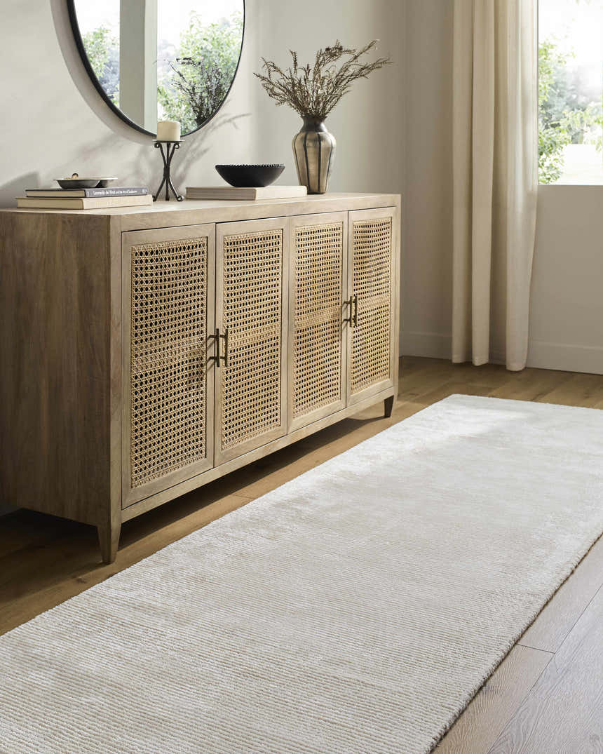 Entryway with off-white Nazih Area Rug runner, light wood cabinet, round mirror, and neutral decor. Roomscene-Runner