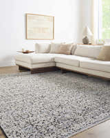 Living room with a neutral sectional sofa and the Haran Cloud Gray Area Rug with a subtle traditional pattern. Roomscene-Rectangle