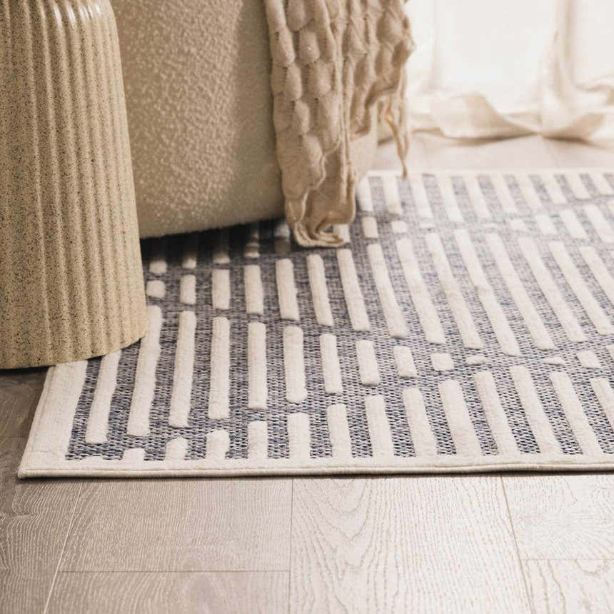Close-up of the Anah Blue Outdoor Rug with a contemporary stripe pattern in denim and off-white. Styleshot