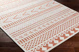 Close-up of the Jove Orange Outdoor Rug, showcasing its bone and terracotta contemporary Southwestern geometric pattern. Corner