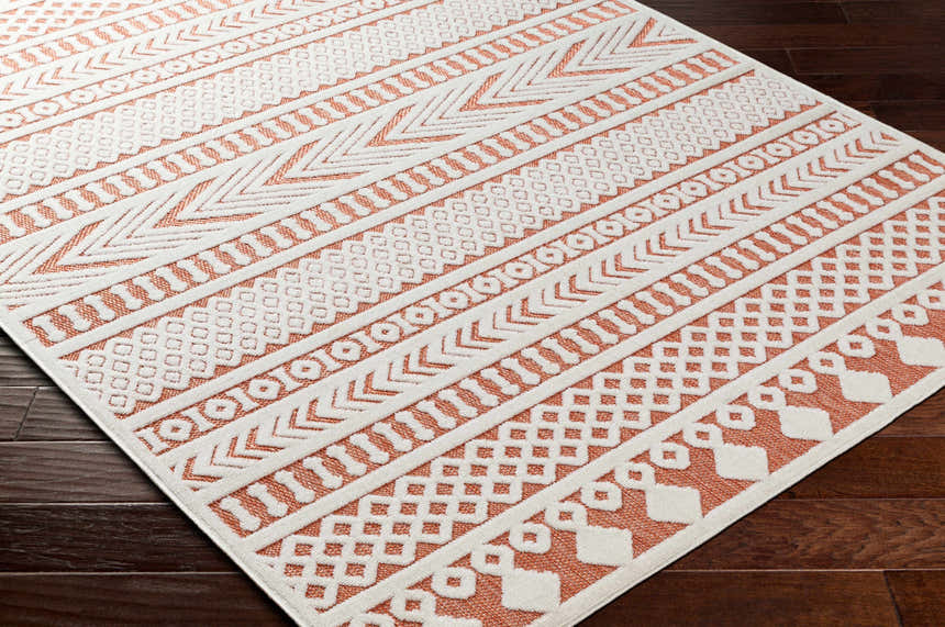Close-up of the Jove Orange Outdoor Rug, showcasing its bone and terracotta contemporary Southwestern geometric pattern. Corner