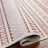 Close-up of the Jove Orange Outdoor Rug showing its bone and terracotta contemporary Southwestern pattern and woven texture. Fold