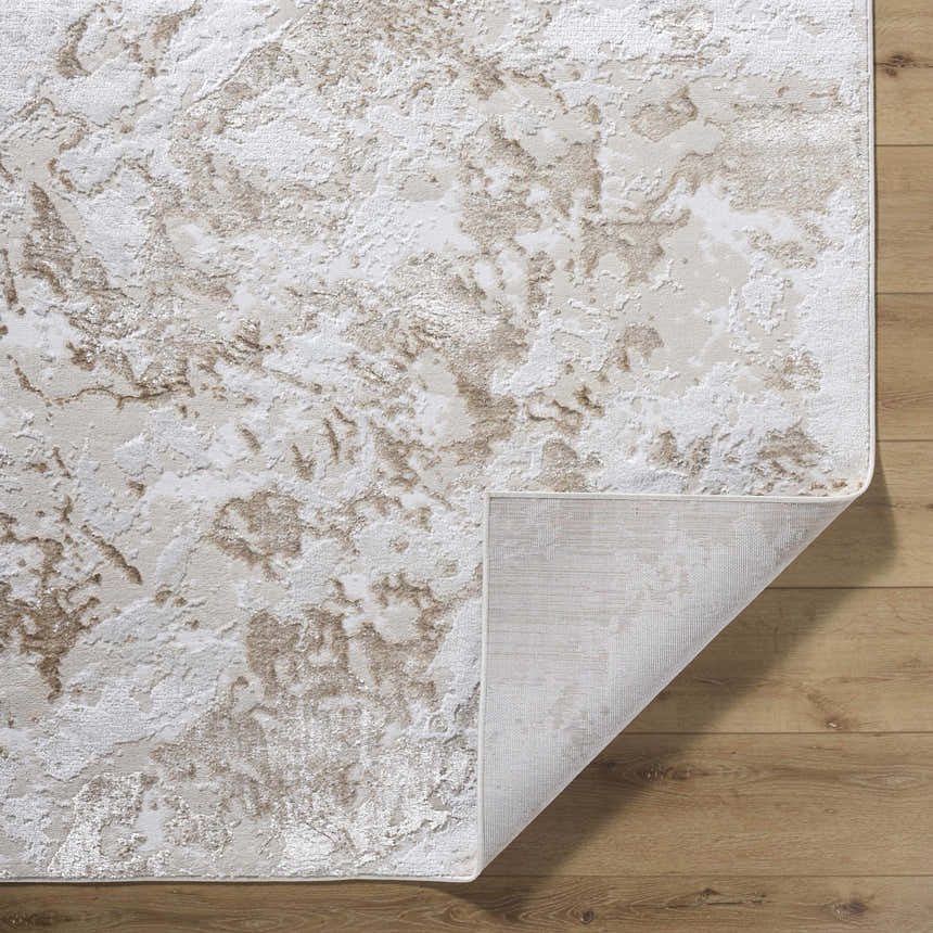 Close-up of the Jaren Tan Area Rug showing its beige, cream, and tan abstract pattern and texture on a wood floor. Fold