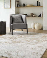 Living room scene with a gray chair and the beige and cream Jaren Tan Area Rug. Roomscene-Rectangle