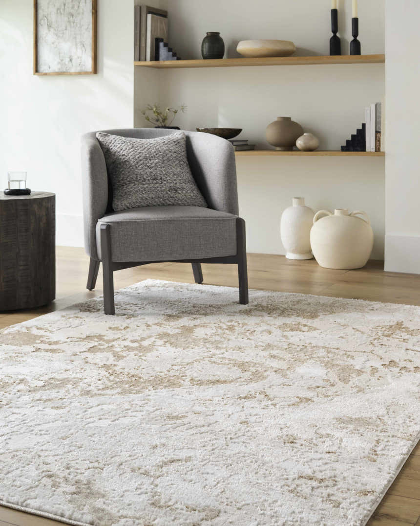 Living room scene with a gray chair and the beige and cream Jaren Tan Area Rug. Roomscene-Rectangle