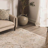 Living room scene with a neutral sofa and Standon Vintage Flat Pile Washable Rug in a faded traditional pattern. Styleshot