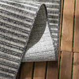 Close up of the Stephan Area Rug showing its gray and cream horizontal stripes and woven texture. Fold