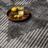Close-up of the Stephan Area Rug showing the black, charcoal, and cream geometric design and woven texture. Styleshot
