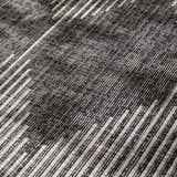 Close-up of the Stephan Area Rug showing a black, charcoal, and cream geometric pattern and woven texture. Texture