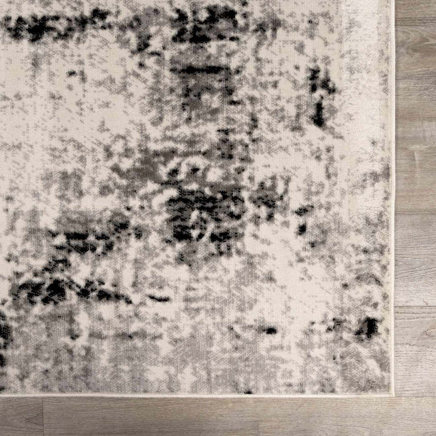 Close-up of the Swansboro Area Rug showing its abstract black, charcoal, and gray pattern on an off-white background. Swatch