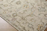Close-up of the hand-tufted Adelle Tufted Oushak Area Rug. Beige wool rug with a traditional floral pattern in tan, beige, and brown. Corner