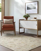 Living room scene with a beige Adelle Tufted Oushak Area Rug, orange chair, and mid-century modern cabinet. Roomscene-Rectangle