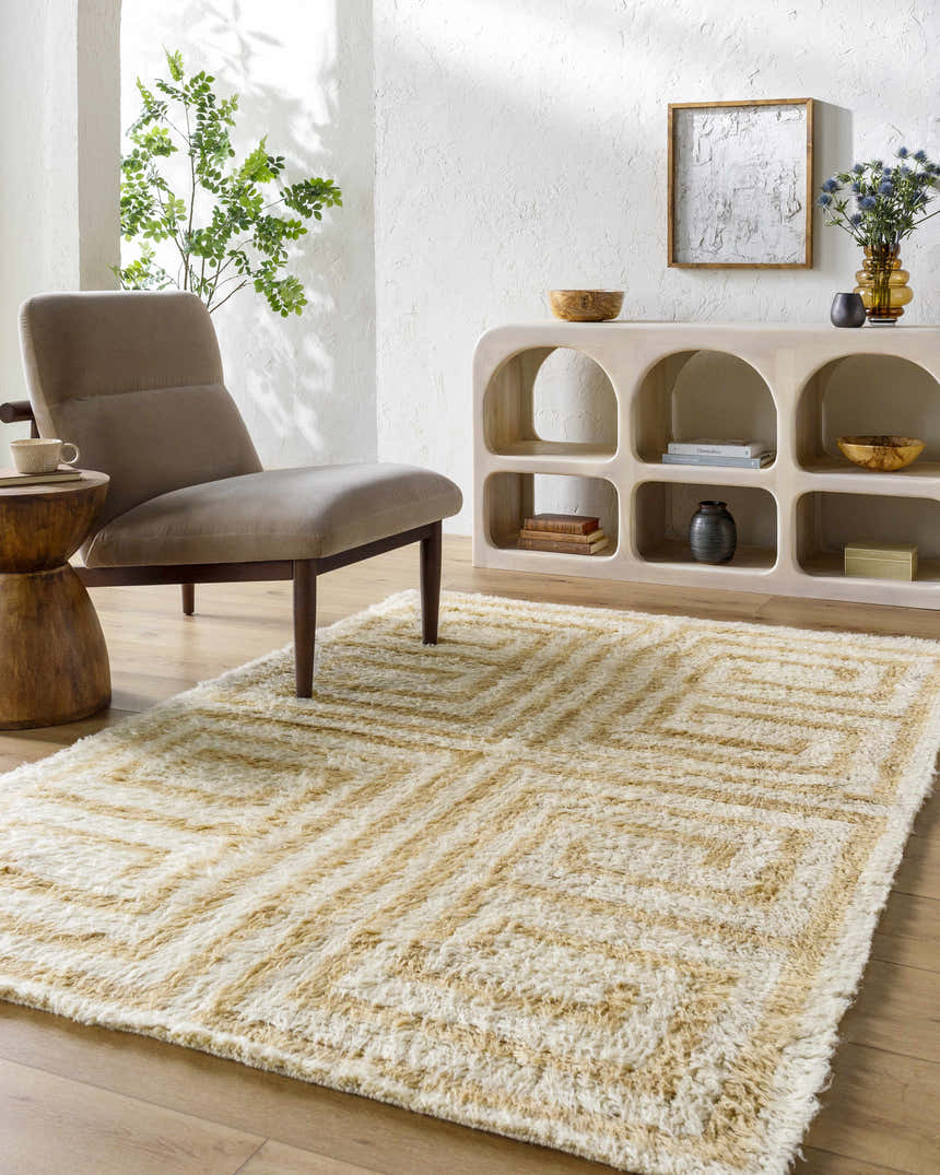 Living room scene with a tan chair and the tan and pearl Wasim Area Rug. Roomscene-Rectangle