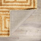 Close-up of the hand-tufted Wasim Area Rug showing its geometric brick red and tan pattern and wool texture. Fold