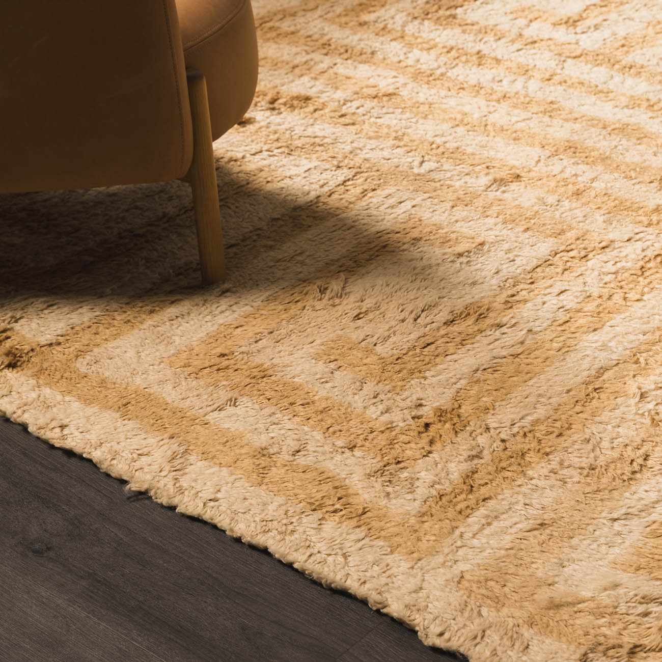Close-up of the tan and light wood geometric pattern on the hand-tufted wool Wasim Area Rug. Styleshot