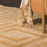 Close up of the tan and camel Wasim Area Rug with geometric pattern and textured wool fibers. Styleshot