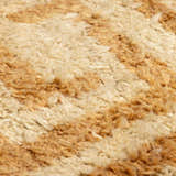 Close up of the hand-tufted Wasim Area Rug, showing its brick red, camel, and tan wool texture. Texture