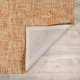 Close up of the Teresita Area Rug, a burnt orange and ivory hand tufted wool rug with a contemporary grid pattern. Fold