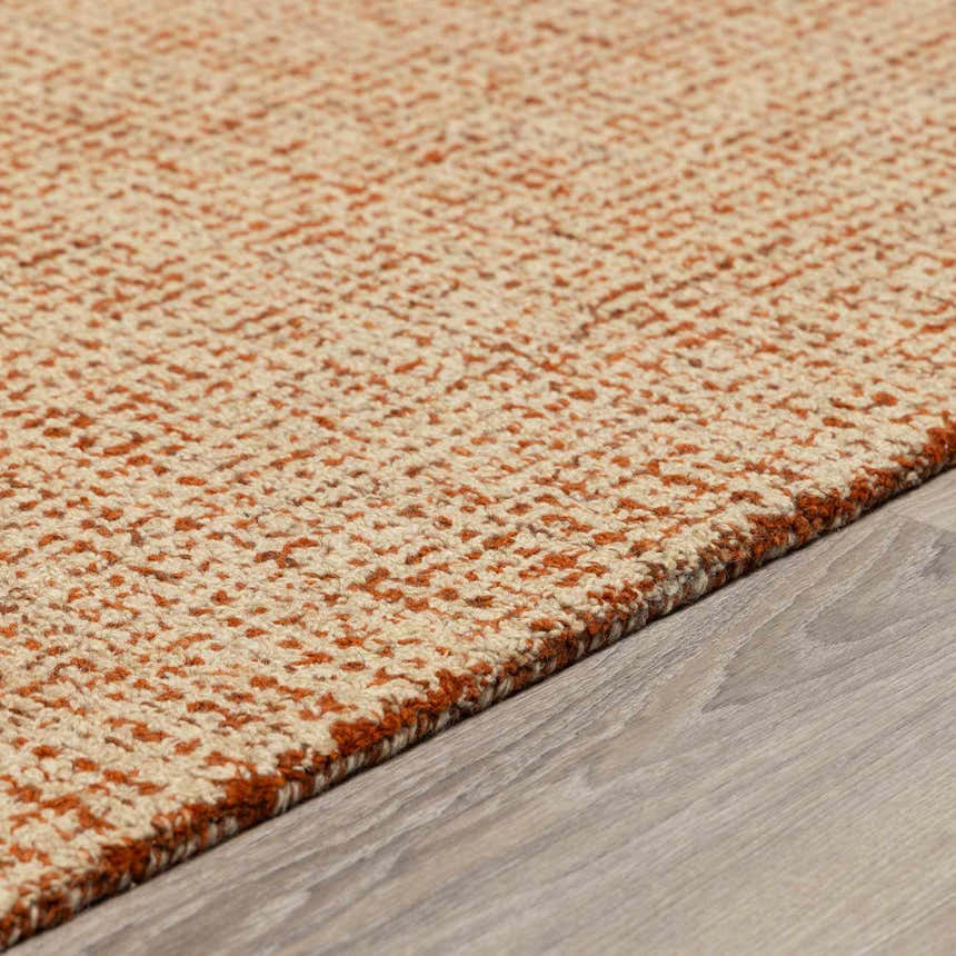 Close-up of the hand tufted Teresita Area Rug. Burnt orange and ivory wool rug with a subtle textured pattern. Pile
