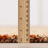 Close-up of Teresita Area Rug showing pile height. Burnt orange and ivory wool texture, hand tufted. Pile