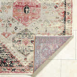 Close-up of the Trudy Area Rug showing a traditional red, black, and cream pattern and machine-woven texture. Fold