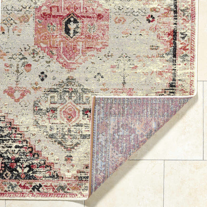 Close-up of the Trudy Area Rug showing a traditional red, black, and cream pattern and machine-woven texture. Fold