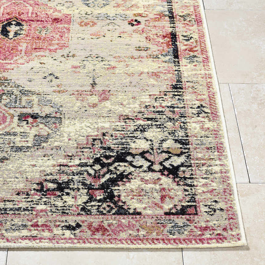 Close up of Trudy Area Rug showing a farmhouse style pattern in cream, pink, and black on tile flooring. Front