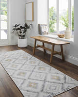 Entryway with a Tyipa Area Rug runner in charcoal, cream, and mustard, styled with a wooden bench and potted plant. Roomscene-Runner