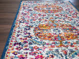Close-up of the Tigril Blue & Orange 2304 Area Rug. Features ivory, navy, red, and orange bohemian-style pattern. Front