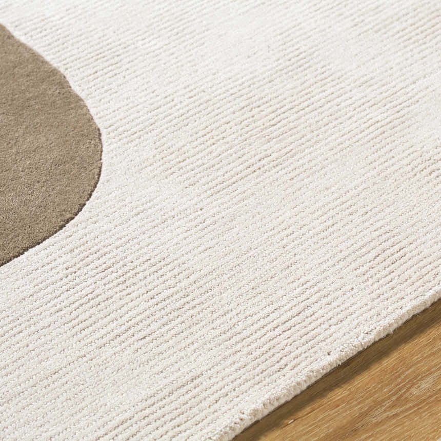 Close up of the Terah Ivory Area Rug showing the ivory wool texture and taupe circle design. Texture